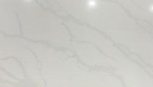 Calacatta Platinum quartz slab with a white background which is enhanced by grey and gold veining.