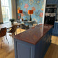 Red uniformly speckled granite kitchen worktops with blue cabinetry