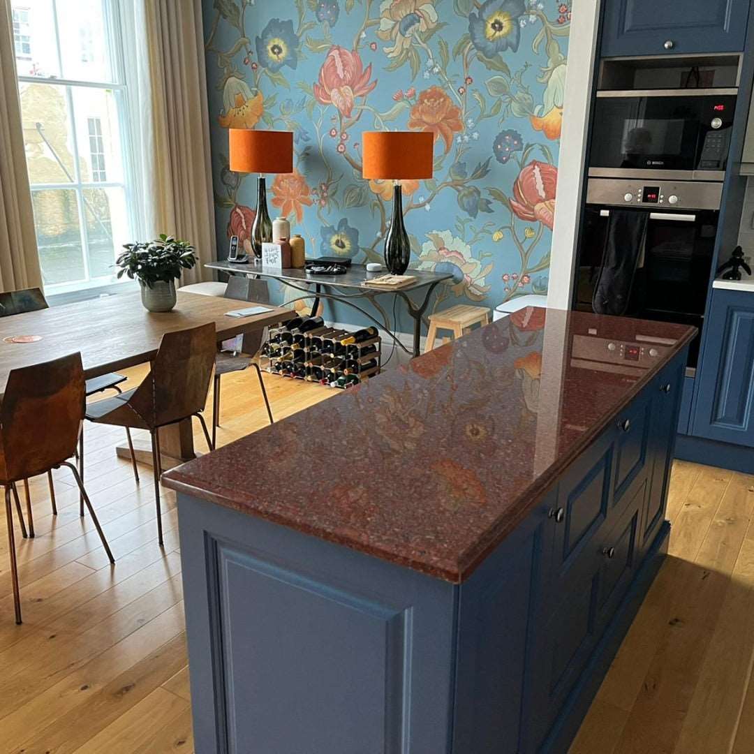 Red uniformly speckled granite kitchen worktops with blue cabinetry