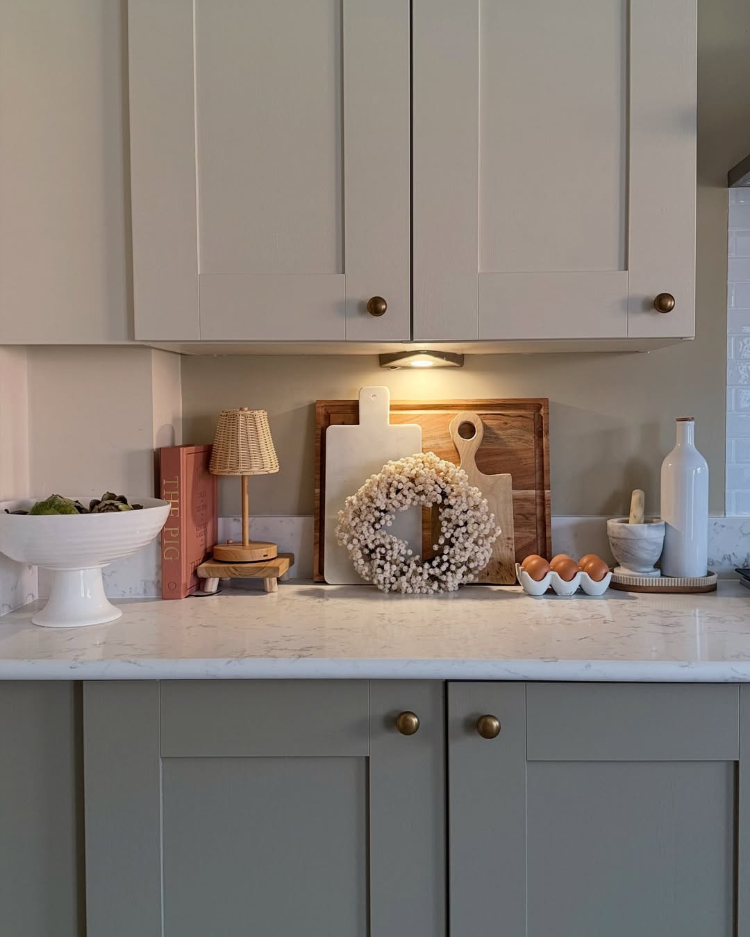 Kitchen counter with decorative items including a wreath, cutting boards, and a small lamp.