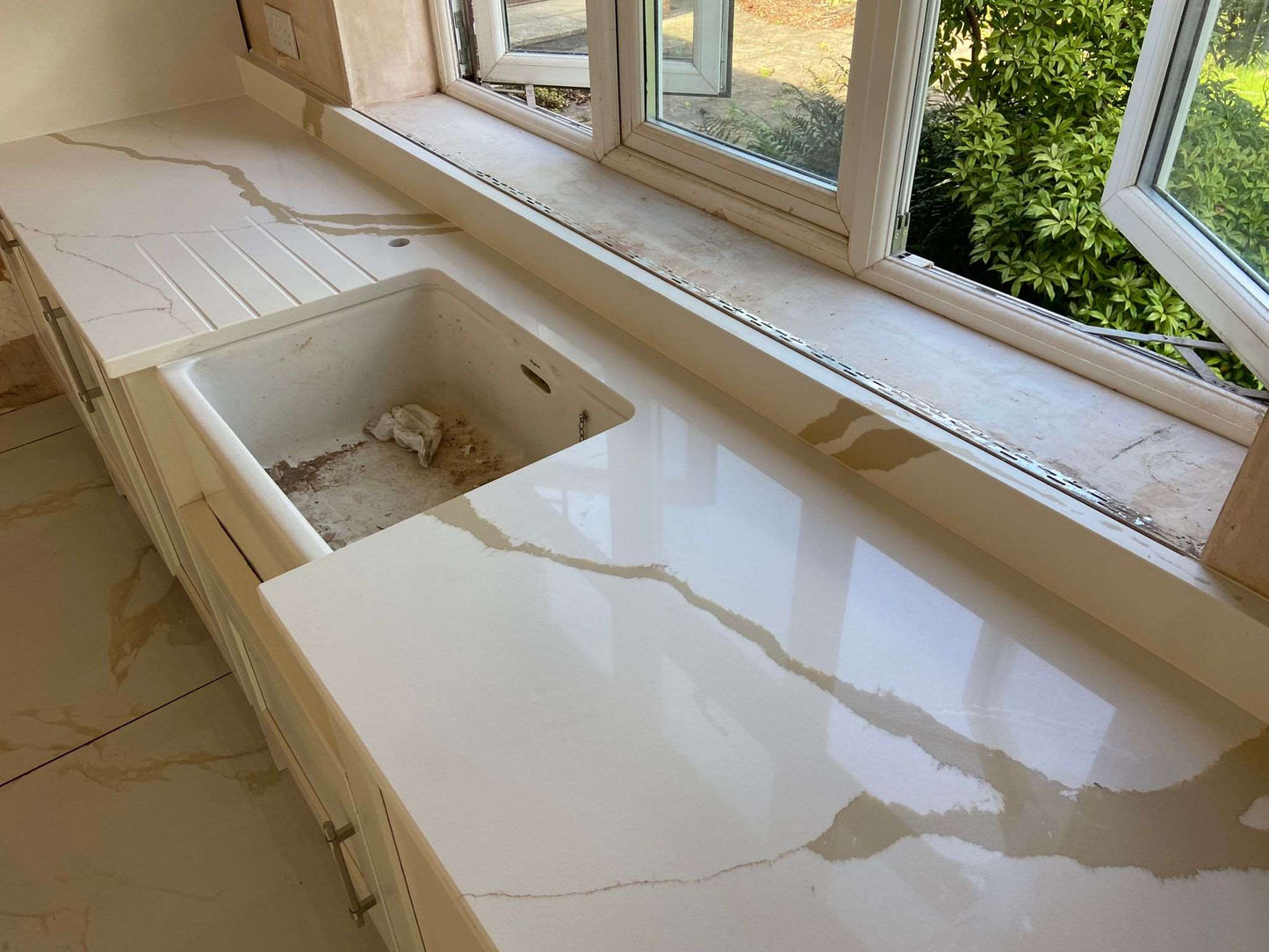 Calacatta Aurous quartz kitchen worktops with a cool white base with vivid gold and subtle grey veining intermixed elegantly.