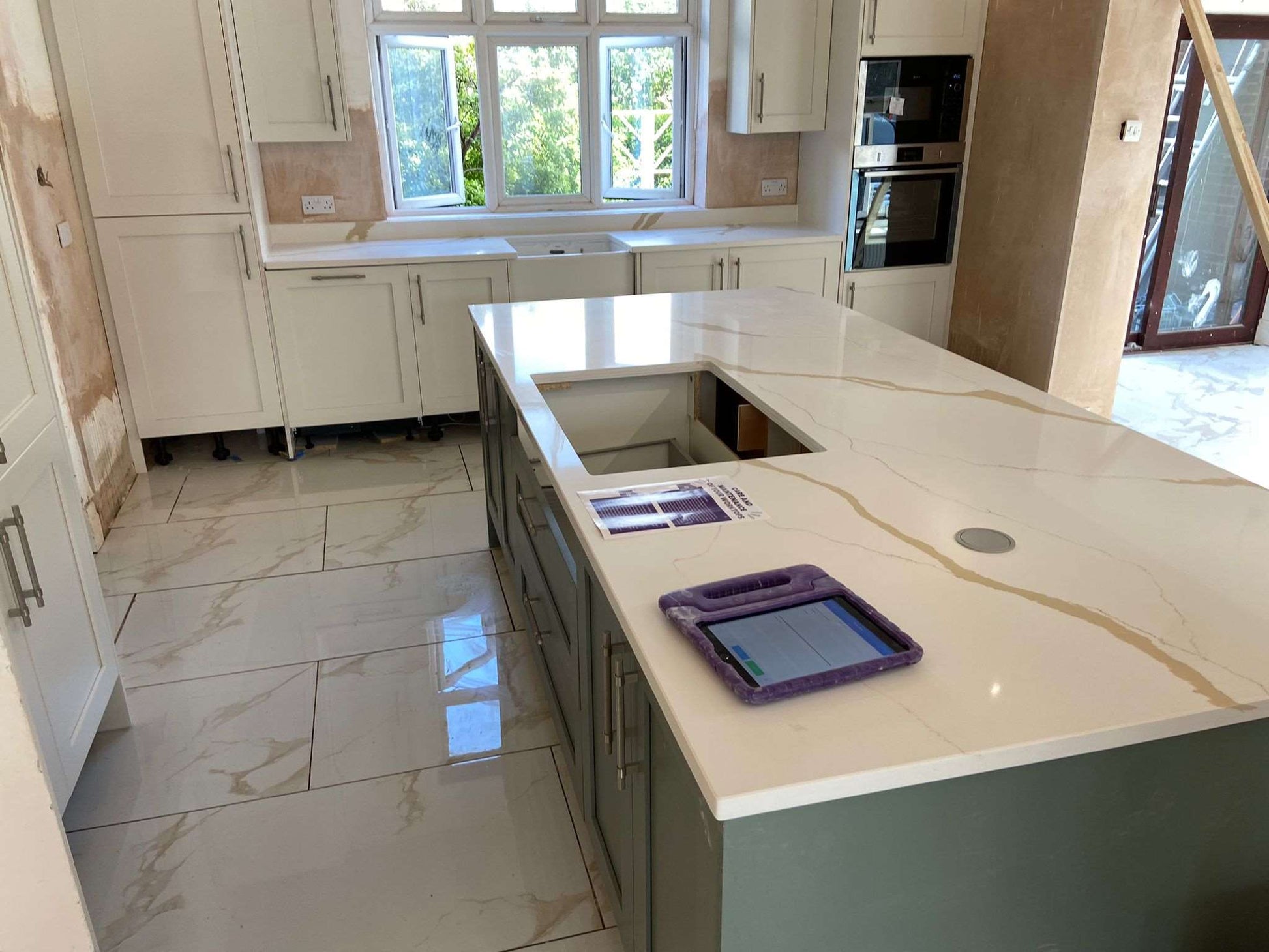 Calacatta Aurous quartz kitchen worktops with a cool white base with vivid gold and subtle grey veining intermixed elegantly.