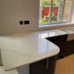 Fugen Calacatta Oro marble effect Quartz kitchen worktops with soft grey veining and gold veins running through it.