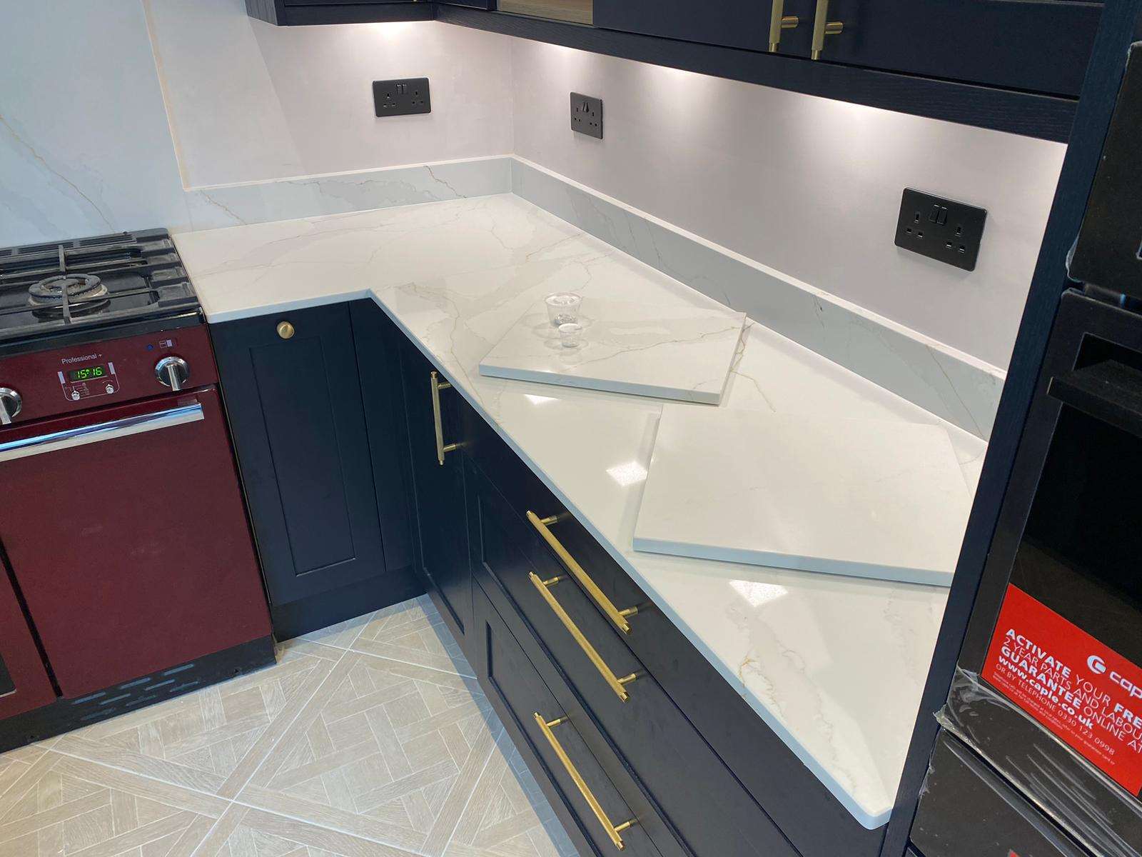 Fugen Calacatta Oro marble effect Quartz kitchen worktops with soft grey veining and gold veins running through it.