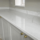 Fugen Avalanche soft white Quartz kitchen worktops with faint veining in a grey colour.