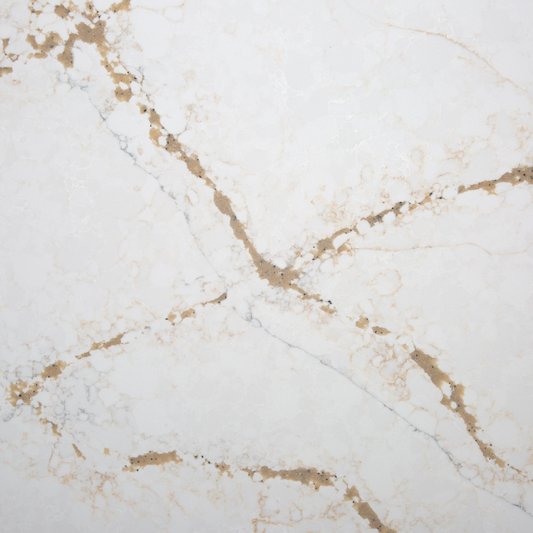 A close-up image of a white quartz countertop with intricate golden veining and patterns.