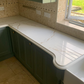 Royal Oro quartz kitchen counter with tiled backsplash and window view