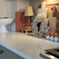 Kitchen counter with carrara white quartz surface, decorative wreath, cutting board, and egg carton.