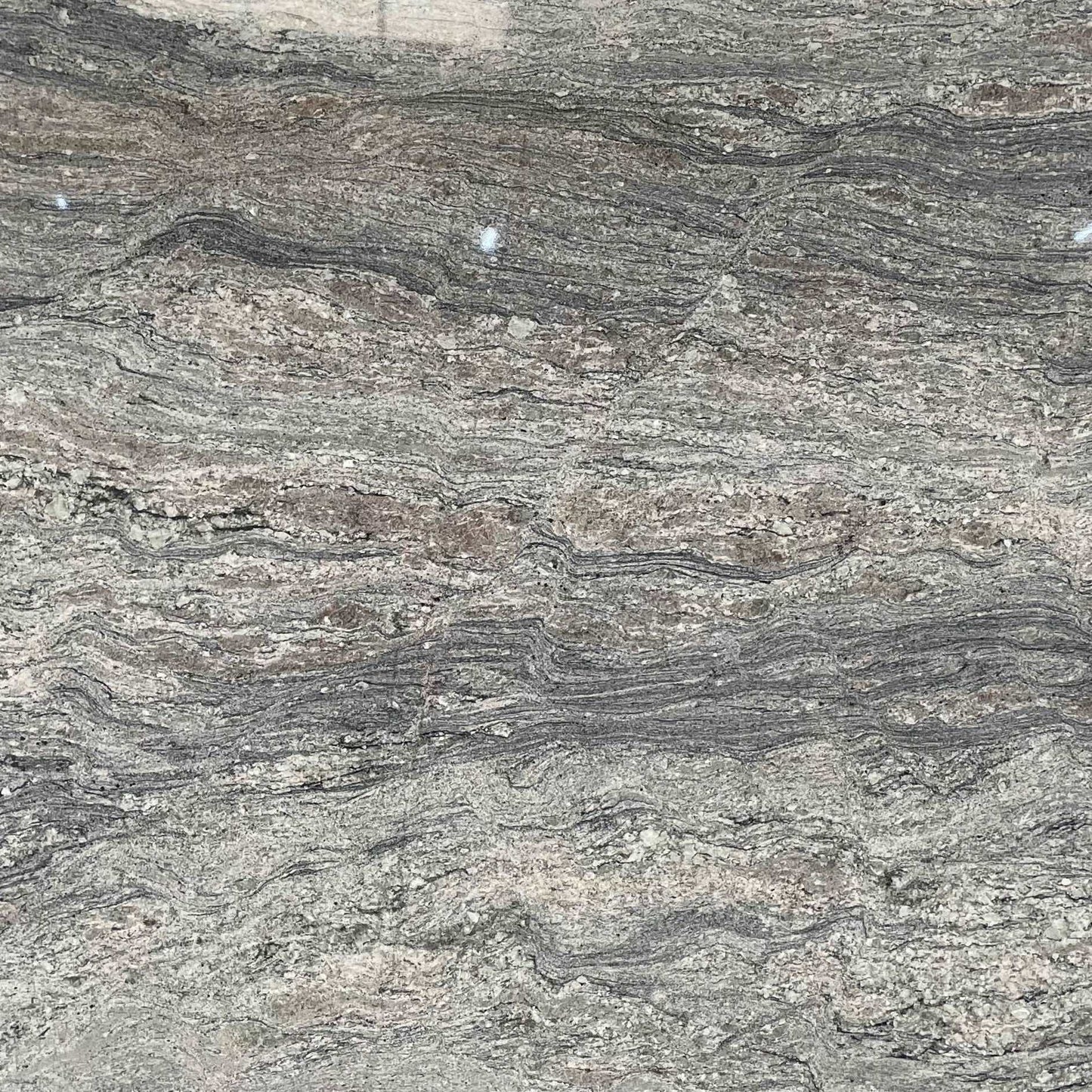 Branco Piracema patterned granite slab with waving colours of blue, grey and lighter colours.
