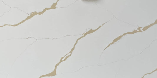 Calacatta Aurous quartz slab with a cool white base with vivid gold and subtle grey veining intermixed elegantly.