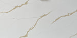 Calacatta Aurous quartz slab with a cool white base with vivid gold and subtle grey veining intermixed elegantly.
