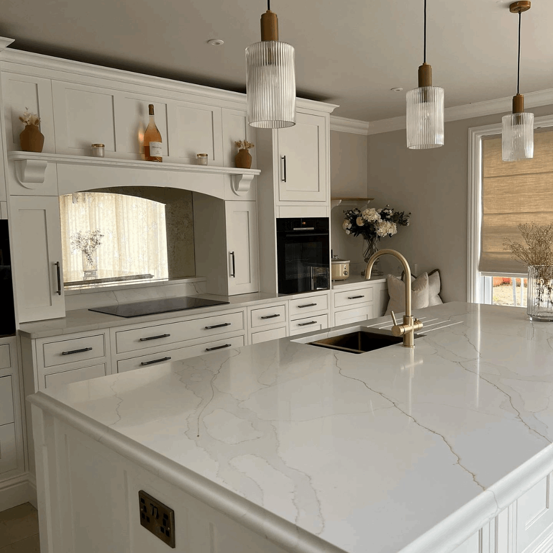 Fugen Calacatta Oro marble effect Quartz kitchen worktops with soft grey veining and gold veins running through it.